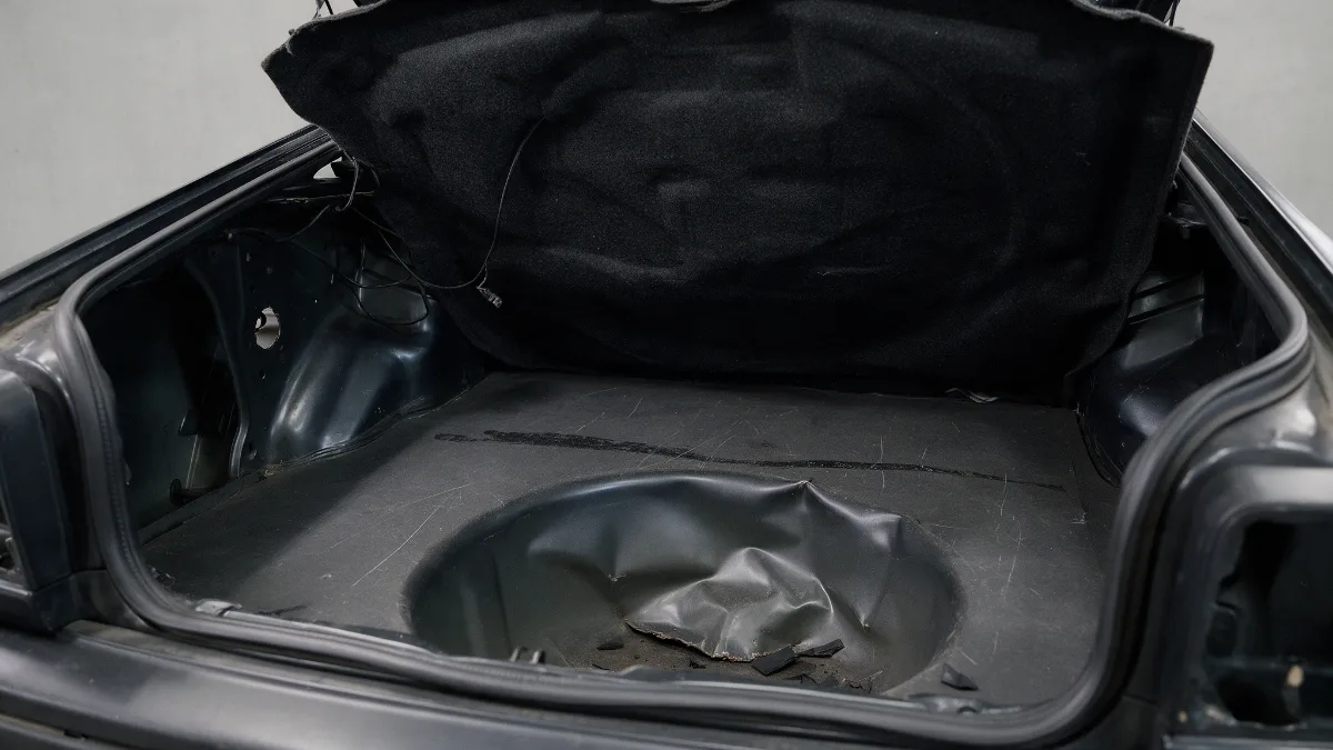 Boot floor and spare wheel well of a car showing deformation after a rear impact